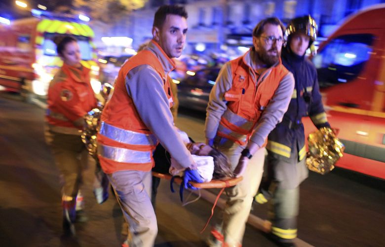 FILE – In this Nov. 13, 2015, file photo, a woman is evacuated from the Bataclan concert hall after a shooting in Paris. The last surviving suspect from the 2015 Paris attacks has told a court he felt “ashamed” after failing to detonate his suicide vest on the bloody night of Nov. 13. (AP Photo/Thibault Camus, File) XCE107 XCE107