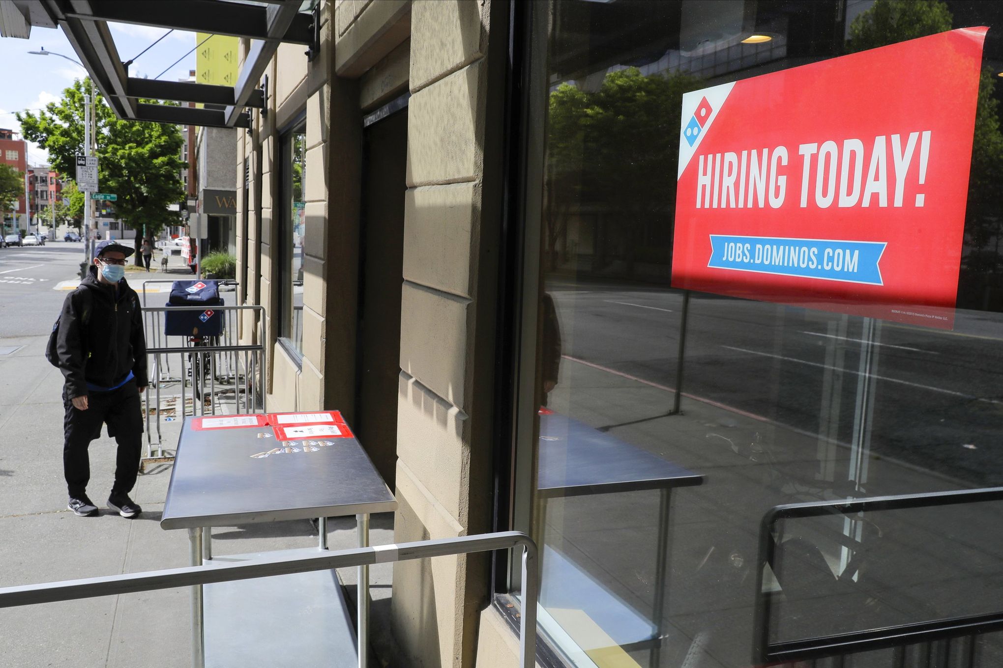 A sign that reads “Hiring Today!” is posted in the window of a Domino’s Pizza store in downtown Seattle.