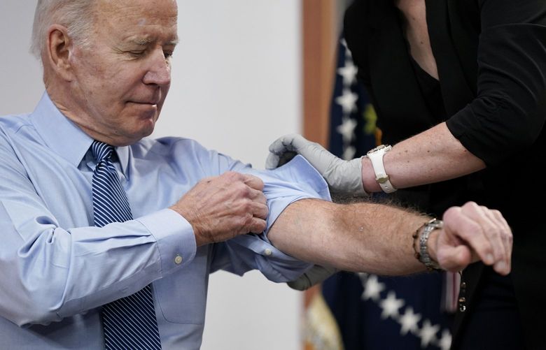 President Joe Biden rolls up his sleeve before receiving his second COVID-19 booster shot in the South Court Auditorium on the White House campus, Wednesday, March 30, 2022, in Washington. (AP Photo/Patrick Semansky) DCPS106 DCPS106
