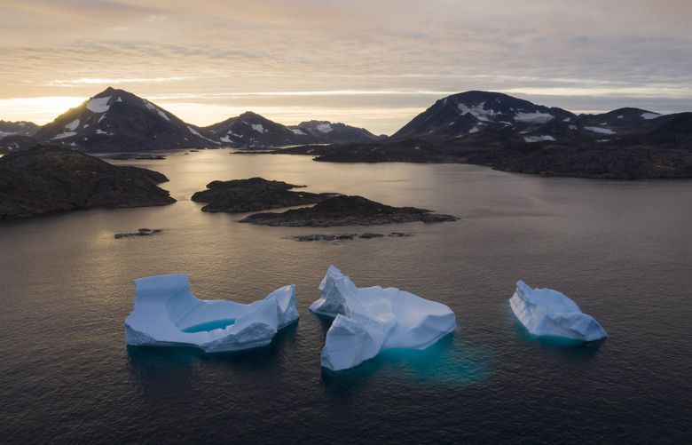 File – Large Icebergs float away as the sun rises near Kulusuk, Greenland, Aug. 16, 2019. A United Nation-backed panel plans to release a highly anticipated scientific report on Monday, April 4, 2022, on international efforts to curb climate change before global temperatures reach dangerous levels. (AP Photo/Felipe Dana, File) DMSC305 DMSC305