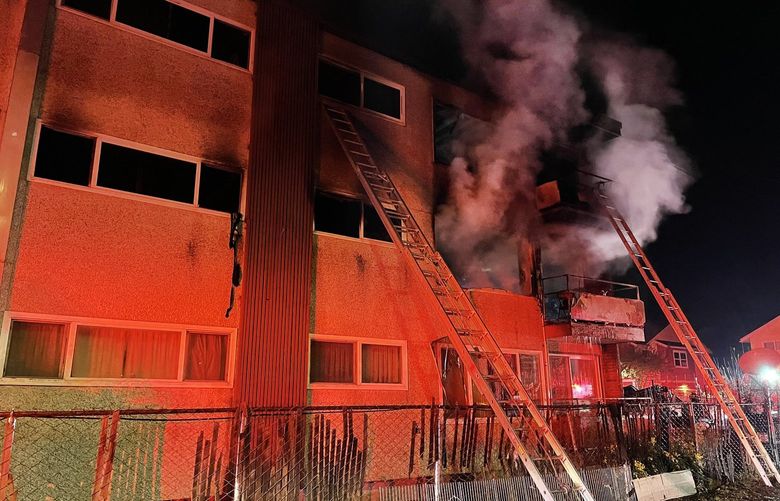 Seattle firefighters battle a fire in a low rise apartment building at the 4800 block of S. Henderson St. in Seattle, Wash. Several residents safely climbed down ground ladders from the apartment. (Seattle Fire Department)