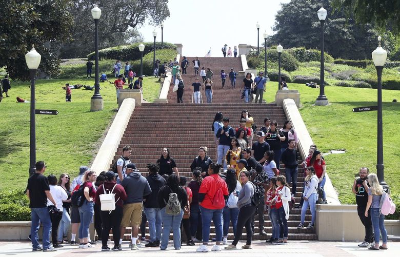 People move about the campus of the University of California, Los Angeles Friday, April 26, 2019. Some students and employees possibly exposed to measles at two Los Angeles universities were still quarantined on campus or told to stay home Friday, but the numbers were dwindling as people were able to show they were vaccinated for the highly contagious disease. The measures were ordered this week at UCLA and California State University, Los Angeles. (AP Photo/Reed Saxon)