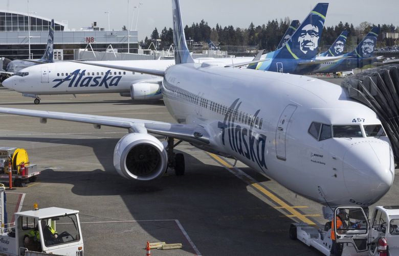 An Alaska Airlines jet taxies towards the runway as others sit at gates at Seattle-Tacoma International Airport Thursday, April 7, 2022. 