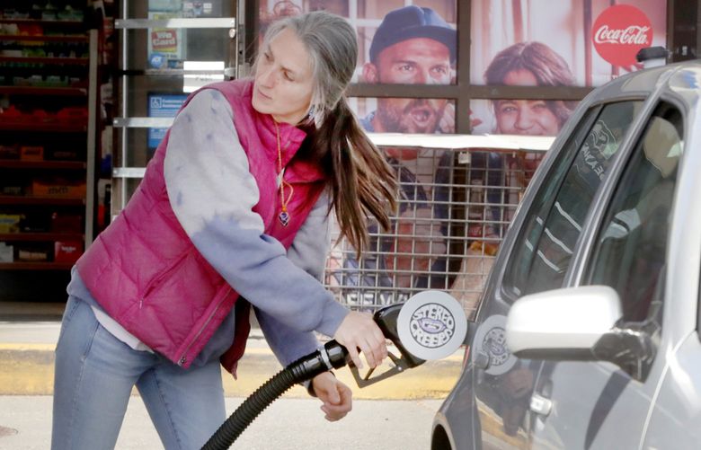 Lisa Windelev fills her car‚Äôs tank at a Ballard gas station.  She said she doesn‚Äôt understand why the fuel prices are so high when we get very little of our oil from Russia. The spread between Washington gas pump prices and the national average grows.
 220076