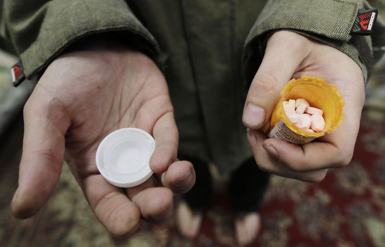 FILE – In this Nov. 14, 2019, photo, Jon Combes holds his bottle of buprenorphine, a medicine that prevents withdrawal sickness in people trying to stop using opiates, as he prepares to take a dose in a clinic in Olympia, Wash. The U.S. Department of Justice made clear, Tuesday, April 2, 2022, that barring the use of medication treatment for opioid abuse is a violation of federal law. (AP Photo/Ted S. Warren, File) NYJO402 NYJO402