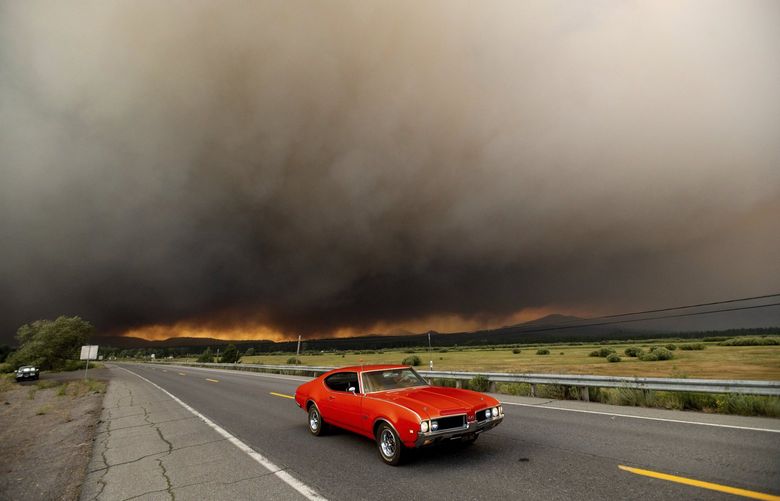 A car leaves Chester, Calif., which is under mandatory evacuation orders as the Dixie Fire burns on the edge of town on Aug. 4, 2021. The region is under red flag fire warnings due to dry, windy conditions. (AP Photo/Noah Berger) CANB102