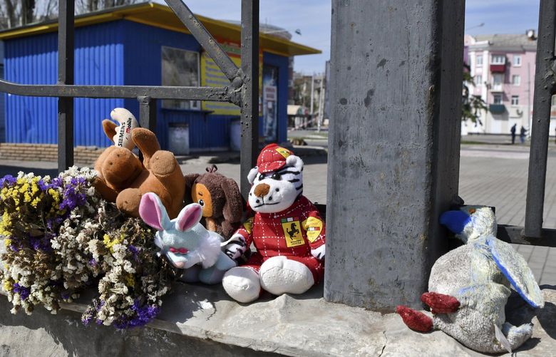 Flowers and toys were left on a fence at the railway station in Kramatorsk, Ukraine, Monday, April 11, 2022. A missile strike killed at least 50 people and wounded dozens more when a rocket hit the railway station on Friday, April 8. (AP Photo/Andriy Andriyenko)