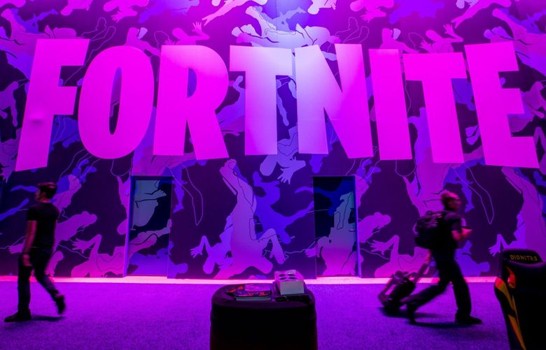 Attendees walk past signage for Epic Games Inc. Fortnite video game during the E3 Electronic Entertainment Expo in Los Angeles, California, U.S., on Wednesday, June 12, 2019. For three days, leading-edge companies, groundbreaking new technologies and never-before-seen products are showcased at E3. Photographer: Kyle Grillot/Bloomberg