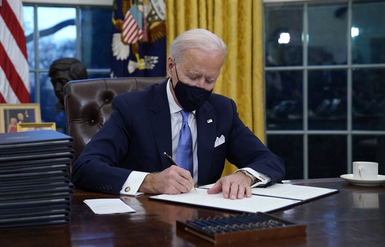 FILE – In this Jan. 20, 2021, file photo, President Joe Biden signs his first executive order in the Oval Office of the White House in Washington.Â Biden laid out an ambitious agenda for his first 100 days in office, promising swift action on everything from climate change to immigration reform to the coronavirus pandemic. Key members of the White House Environmental Justice Advisory Council say one year into the Biden Administration’s commitment that 40% of all benefits from climate investment go to disenfranchised communities, not enough has been done. (AP Photo/Evan Vucci, File) NYSB228 NYSB228