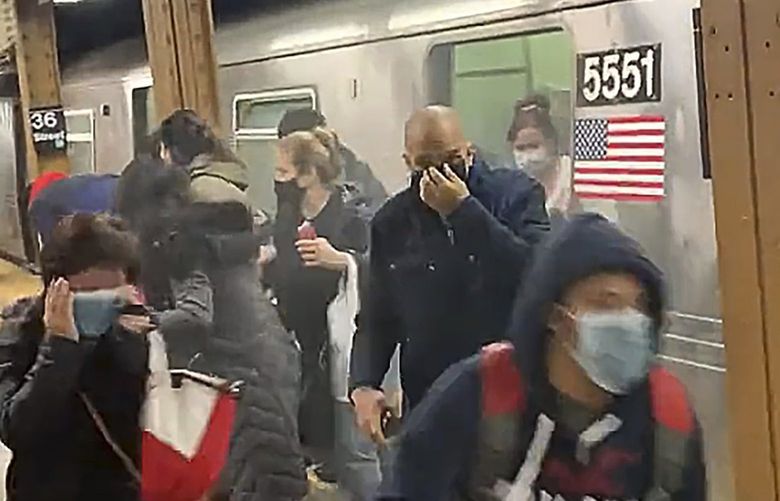 In this photo from social media video, passengers run from a subway car in a station in the Brooklyn borough of New York, Tuesday, April 12, 2022. A gunman filled a rush-hour subway train with smoke and shot multiple people Tuesday, leaving wounded commuters bleeding on a Brooklyn platform as others ran screaming, authorities said. Police were still searching for the suspect. (Will B Wylde via AP) (Will B. Wylde via AP) NYRD221 NYRD221