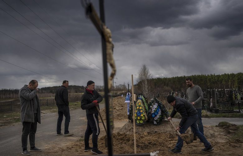 Anatoliy Morykin, 45, left, mourns the death of his mother Valentyna Morykina, 82, who died in a retirement home due to poor living conditions during the Russian invasion in Bucha, on the outskirts of Kyiv, Ukraine, Tuesday, April 12, 2022. (AP Photo/Rodrigo Abd) NYAG501 NYAG501