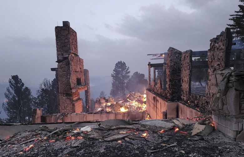 The remains of a home left after a wildfire spread through the Village of Ruidoso, New Mexico, on Wednesday, April 13, 2022. Officials say a wildfire has burned about 150 structures, including homes, in the New Mexico town of Ruidoso. (Alexander Meditz via AP) LA303 LA303