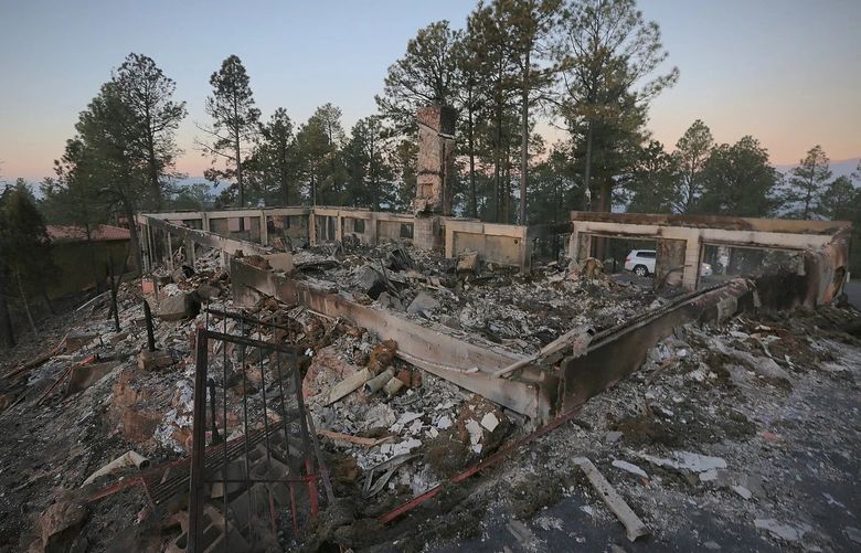 A two-story house continues to smolder following the McBride Fire in Ruidoso, New Mexico, on Thursday, April 14, 2022.   Authorities say firefighters have kept a wind-driven blaze from pushing further into a mountain community in the southern part of the state. (Justin Garcia /The Las Cruces Sun News via AP) NMLCR403 NMLCR403