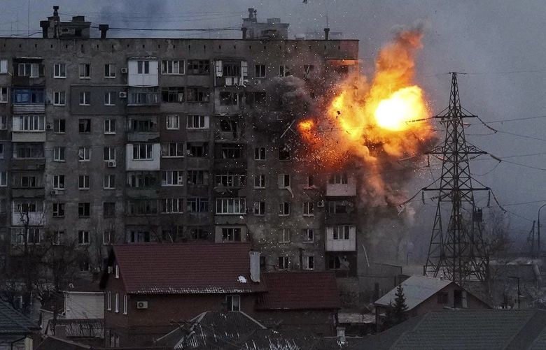 FILE – An explosion is seen in an apartment building after Russian’s army tank fires in Mariupol, Ukraine, Friday, March 11, 2022. (AP Photo/Evgeniy Maloletka, File) UBC101 UBC101