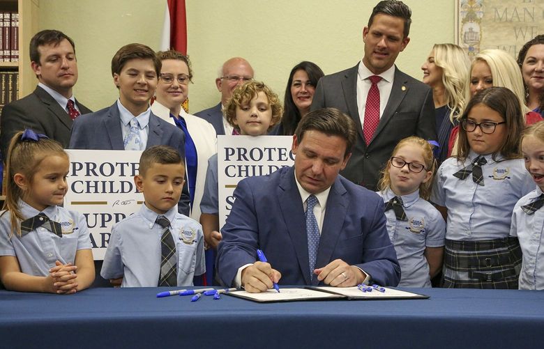 Florida Gov. Ron DeSantis signs the Parental Rights in Education bill at Classical Preparatory School in Spring Hill, Florida, on March 28, 2022. (Douglas R. Clifford/Tampa Bay Times/TNS) 45294331W 45294331W