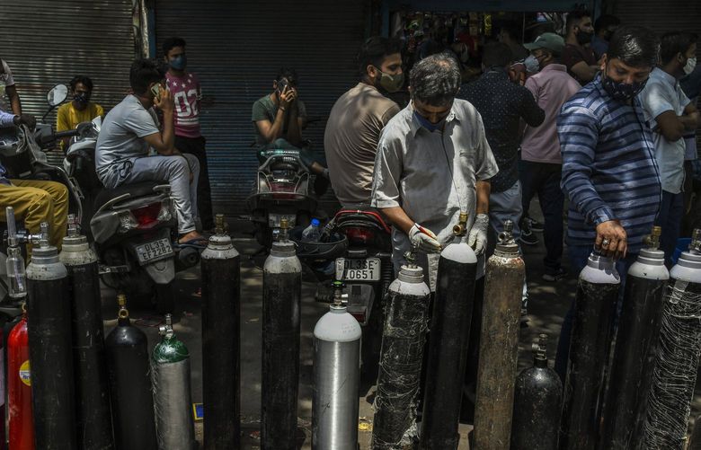 FILE — People wait to refill oxygen cylinders for COVID patients in New Delhi, April 27, 2021. The World Health Organization has calculated that 15 million people have died as a result of the pandemic, far more than earlier estimates, but the release of those numbers has been delayed for months because of objections from India, which disputes the calculation of how many of its citizens died. (Atul Loke/The New York Times) XNYT XNYT