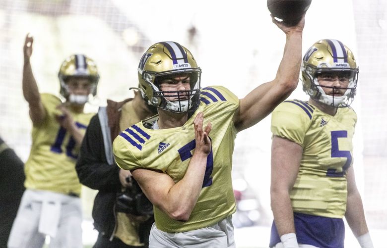 Washington quarterback Sam Huard throws the ball in UW spring football practice number four. Quarterback Dylan Morris is at right. 220024