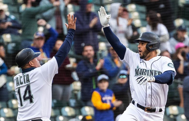 Eugenio Suarez celebrates his 1st inning 3-run homer with third base coach Manny Acta Tuesday.

The Texas Rangers played the Seattle Mariners in the first game of a three-game set Tuesday, April 19, 2022 at T-Mobile Park, in Seattle, WA. 220167