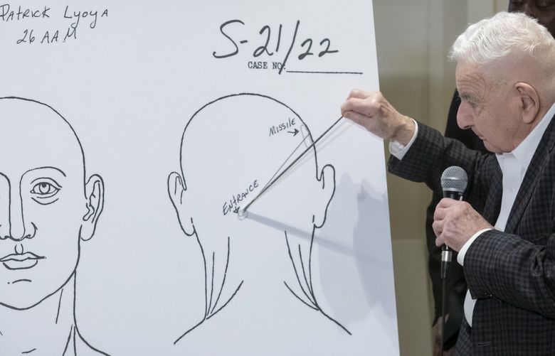 Forensic pathologist Dr. Werner Spitz uses a chart to demonstrate the direction of the bullet that killed Patrick Lyoya during a press conference at the Westin hotel in Detroit, Tuesday, April 19, 2022. Lyoya died of a gunshot wound to the back of head after a confrontation with a Grand Rapids, Mich., police officer during an April 4 traffic stop according to Dr. Spitz. (David Guralnick/Detroit News via AP) MIDTN504 MIDTN504