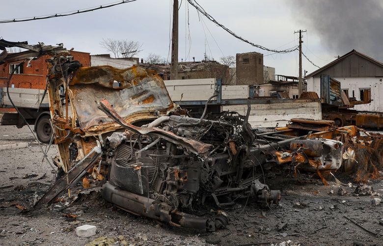 Burned vehicles are seen at the destroyed part of the Illich Iron & Steel Works Metallurgical Plant, as smoke rises from the Metallurgical Combine Azovstal during heavy fighting, in an area controlled by Russian-backed separatist forces in Mariupol, Ukraine, Monday, April 18, 2022. Mariupol, a strategic port on the Sea of Azov, has been besieged by Russian troops and forces from self-proclaimed separatist areas in eastern Ukraine for more than six weeks. (AP Photo/Alexei Alexandrov) MAR111 MAR111