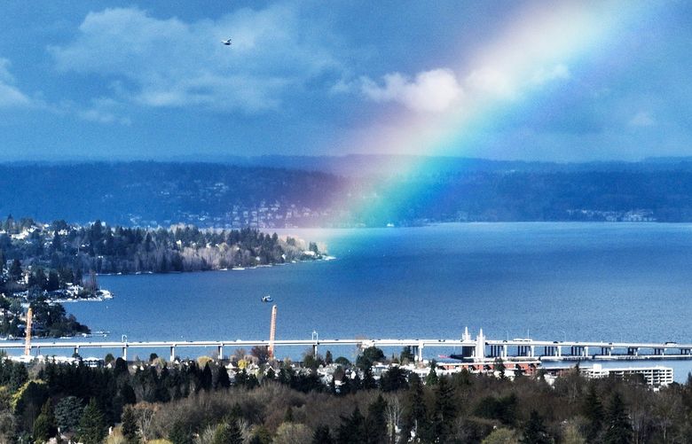 A rainbow appears over Lake Washington and the 520 bridge between rain showers Wednesday afternoon. This view is looking north with the rainbow appearing to touch the Magnuson Park area of Seattle.