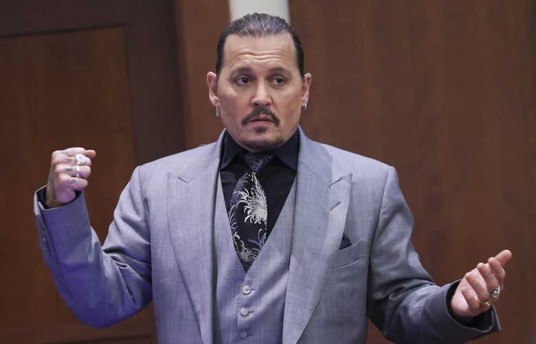 Actor Johnny Depp  demonstrates what he claims was an alleged attack by his ex-wife Amber Heard, as he testifies during the trial at the Fairfax County Circuit Court in Fairfax, Va., Wednesday, April 20, 2022. Actor Johnny Depp sued his ex-wife Amber Heard for libel in Fairfax County Circuit Court after she wrote an op-ed piece in The Washington Post in 2018 referring to herself as a “public figure representing domestic abuse.” (Evelyn Hockstein/Pool via AP) WX518 WX518