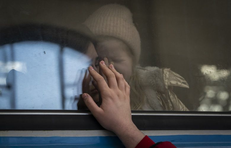 FILE – Displaced Ukrainians on a Poland-bound train bid farewell in Lviv, western Ukraine, Tuesday, March 22, 2022. The U.N. refugee agency says more than 5 million refugees have fled Ukraine since Russian troops invaded the country. The agency announced the milestone in Europeâ€™s biggest refugee crisis since World War II on Wednesday, April 20, 2022. (AP Photo/Bernat Armangue, File) XLON501 XLON501