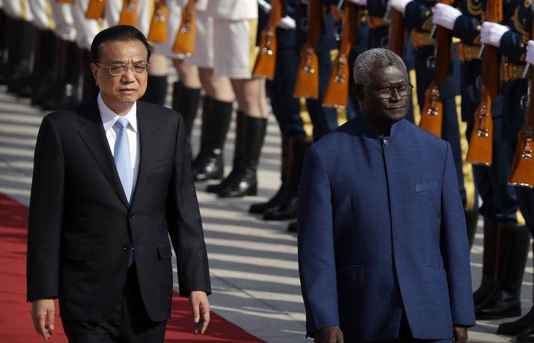 FILE – Chinese Premier Li Keqiang, left, and Solomon Islands Prime Minister Manasseh Sogavare review an honor guard during a welcome ceremony at the Great Hall of the People in Beijing, Wednesday, Oct. 9, 2019. The U.S. on Monday, April 18, 2022, announced it is sending two top officials to the Solomon Islands following a visit last week by an Australian senator over concerns that China could establish a military presence in the South Pacific island nation. (AP Photo/Mark Schiefelbein, File) BKWS302 BKWS302