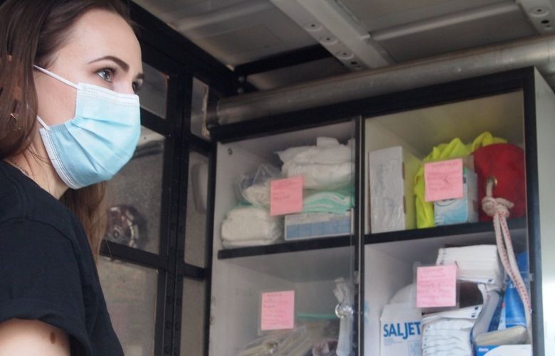 Liz Mitchell, a CAHOOTS member, checks medical and other supplies in a crisis intervention van.