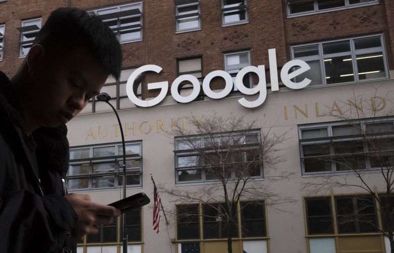 FILE – In this file photo dated Monday, Dec. 17, 2018, a man using a mobile phone walks past Google offices in New York. Monopoly or not, small business ownersâ€™ biggest complaint about Google is that its advertising policies favor companies with big marketing budgets. (AP Photo/Mark Lennihan, File)