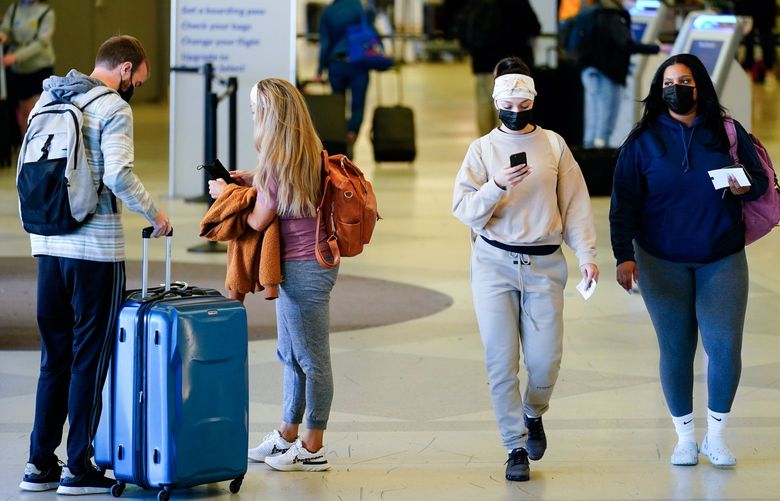 FILE – Travelers wearing protective masks as a precaution against the spread of the coronavirus move about the a terminal at the Philadelphia International Airport in Philadelphia, April 19, 2022. Airlines have banned several thousand passengers since the pandemic started for refusing to wear masks. Now they want most of those passengers back. Officials with United Airlines and American Airlines said Thursday, April 21, 2022 that they will lift the bans now that masks are optional on flights. (AP Photo/Matt Rourke, file) NYPS203 NYPS203