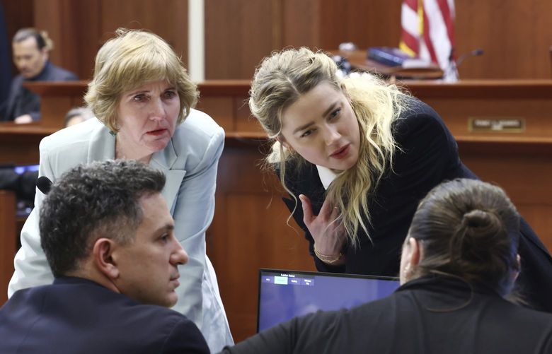 Actor Amber Heard speaks with her legal team as actor Johnny Depp returns to the stand after a lunch recess at the Fairfax County Circuit Court in Fairfax, Va., Thursday, April 21, 2022. Actor Johnny Depp sued his ex-wife Amber Heard for libel in Fairfax County Circuit Court after she wrote an op-ed piece in The Washington Post in 2018 referring to herself as a “public figure representing domestic abuse.” (Jim Lo Scalzo/Pool Photo via AP) WX431 WX431