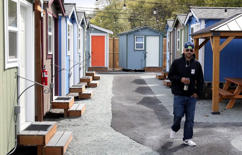 Staffer Michael Cleveland, village organizer, at the empty South End tiny home village in Rainier Beach. They are all wired and ready for move in but so far feuding and funding has kept them off limits for use by homeless people.  220201