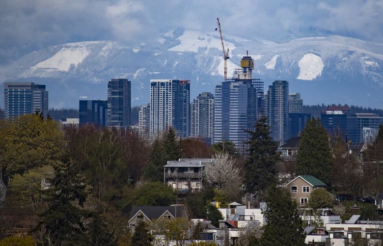 Downtown Bellevue, in the background, is seen with homes in the foreground between Seattle’s Central District and Judkins Park neighborhoods, Sunday, April 10, 2022. This view is looking east from north Beacon Hill. 220091