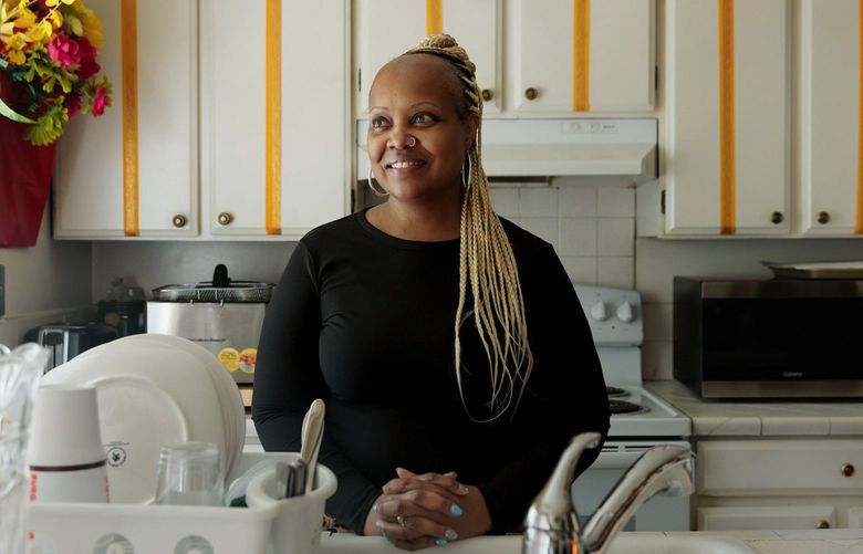 Angela Wells is photographed in her kitchen at The Arches Apartments in south Seattle Thursday, April 14, 2022. Wells, a Harborview Medical Center employee, raised her family with her high school sweetheart in the apartments. 220114
