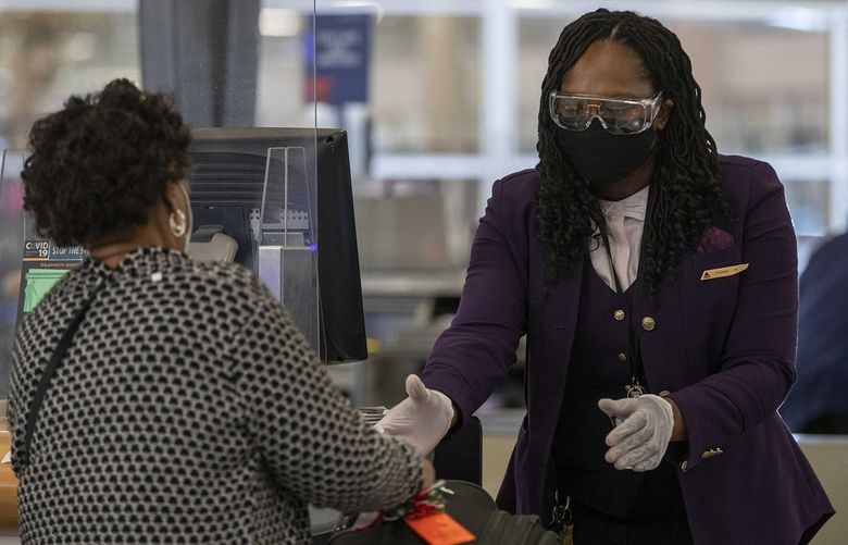 A Delta Air Lines employee handles a passenger’s luggage while wearing goggle, gloves and a face mask in the domestic terminal at Hartsfield-Jackson Atlanta International Airport in Atlanta on Monday, Nov. 23, 2020. A federal judge in Tampa, Florida, in April 2022, issued an order that voided the Centers for Disease Control and Preventionâ€™s mask mandate for those on public transportation. (Alyssa Pointer/Atlanta Journal-Constitution/TNS) 45932228W 45932228W