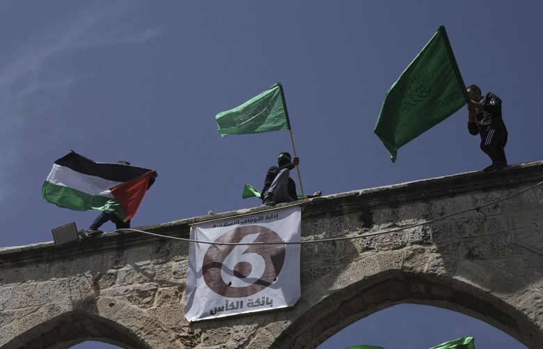 Protesters wave the Palestinian and Hamas flags after Friday prayers during the Muslim holy month of Ramadan, hours after Israeli police clashed with protesters at the Al Aqsa Mosque compound, in Jerusalem’s Old City, Friday, April 22, 2022. (AP Photo/Mahmoud Illean) XMA125 XMA125