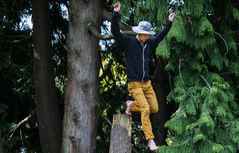 Bumbu, who prefers going by just one of his names, works on his balance in Volunteer Park, Sunday, April 24, 2022 in Seattle. The Seattleite said he is working on getting used to the heights and “exploring” movement during an informal meet-up of Evolve Move Play, founded by Rafe Kelley, which according to its website promotes “Movement Training for Humans.” For more information go to evolvemoveplay.com.