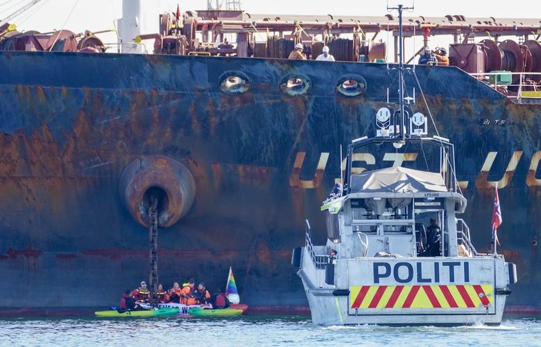 A police boat at the scene asm embers of Greenpeace stage a protest by the the Ust Luga ship carrying Russian oil, in Ã…sgardstrand, Norway, Monday, April 25, 2022. (Ole Berg-Rusten/NTB via AP) AMB804 AMB804