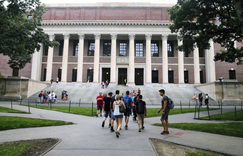 FILE – In this Aug. 13, 2019 file photo, students walk near the Widener Library in Harvard Yard at Harvard University in Cambridge, Mass. Ismail Ajjawi, 17, a Palestinian student who was denied entry to the United States just days before he was scheduled to start classes at Harvard University, has been admitted to the country. The university confirmed that Ajjawi was on campus as classes began Tuesday, Sept. 3, 2019. (AP Photo/Charles Krupa, File)