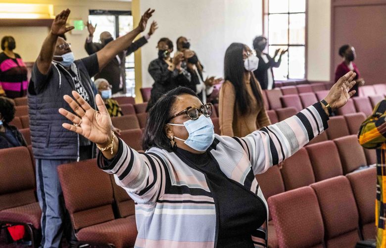 Monette Hearn, center, who has been a congregant at Mount Calvary Christian Center for 10 years, sings with her community members during the praise service on Sunday, March 27, 2022.