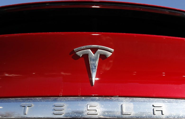 FILE – In this Feb. 2, 2020, file photo, the company logo appears on an unsold 2020 Model X at a Tesla dealership in Littleton, Colo. Tesla reported Wednesday, April 20, 2022, that its first-quarter net earnings were over seven times greater than a year ago, powered by strong sales despite global supply chain kinks and pandemic-related production cuts in China. (AP Photo/David Zalubowski, File) NYPH750 NYPH750