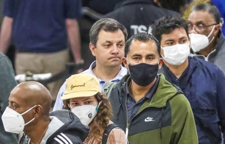 Travelers wearing masks and others without them go through the security line at Hartsfield-Jackson International Airport on Tuesday, April 19, 2022, in Atlanta, Ga. The airport issued a statement Tuesday morning saying masks are now “optional for employees, passengers, and visitors” at the airport. (John Spink/Atlanta Journal-Constitution via AP) GAATJ400