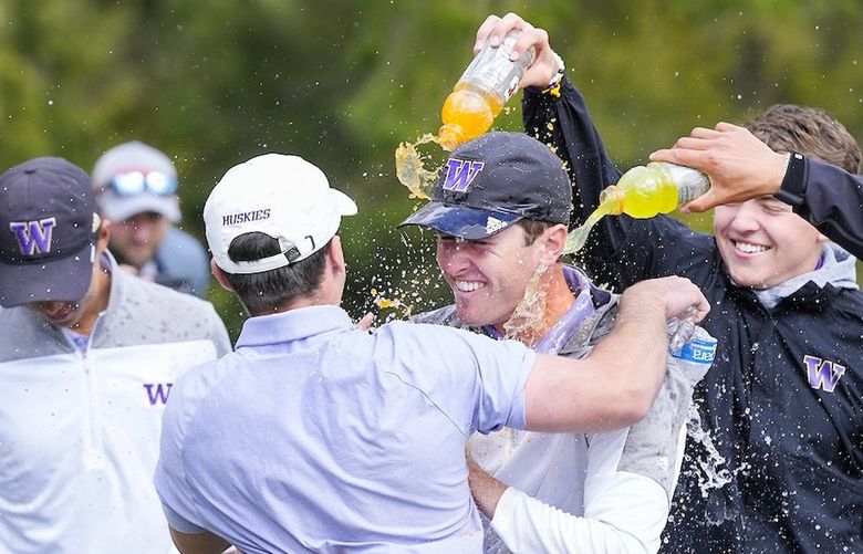 Noah Woolsey, right, is hugged by RJ Manke and doused by Gatorade from the rest of the UW Golf team Wednesday, April 27, 2022.