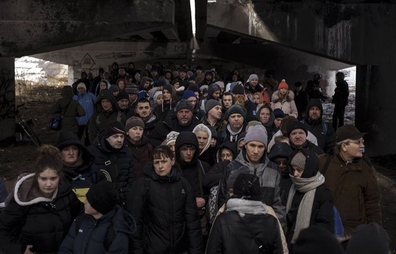 FILE – People crowd under a destroyed bridge as they try to flee, crossing the Irpin river on the outskirts of Kyiv, Ukraine, Tuesday, March 8, 2022. Russia’s relentless digital assaults on Ukraine may have caused less damage than many anticipated. But most of its hacking is focused on a different goal that gets less attention but has chilling potential consequences: data collection. (AP Photo/Felipe Dana, File) NY448 NY448
