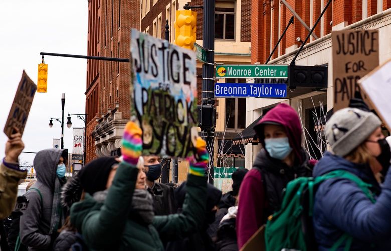 Protesters after the killing of Patrick Lyoya in Grand Rapids, Mich., on April 16, 2022, pass a street named for Breonna Taylor, the Black emergency room technician and Grand Rapids native who was fatally shot by Louiville officers in 2020. The April 4 episode began as the kind of low-level traffic stop that routinely occurs across the United States, the mismatched plate a possible sign that the car was stolen. But it was also the type of stop that has raised questions of racial profiling, use of excessive force and the overpolicing of traffic stops, prompting public debate and some cities to ban or restrict such interventions. (Emily Elconin/The New York Times) XNYT94 XNYT94