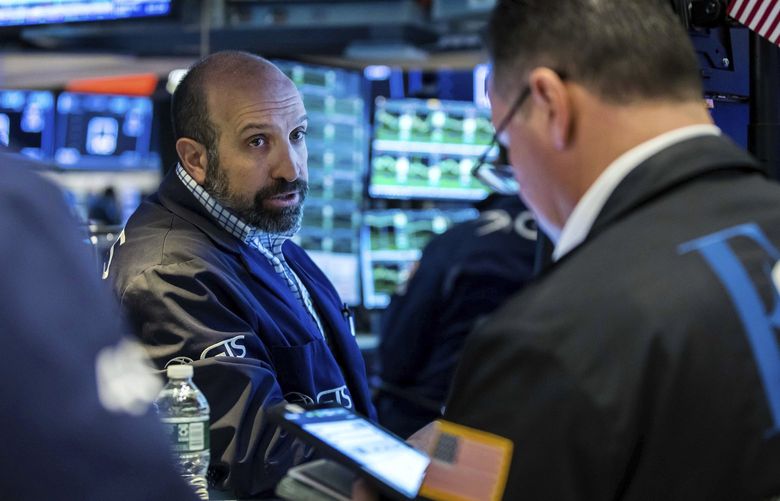 In this photo provided by the New York Stock Exchange, specialist James Denaro works with traders at his post on the floor, Wednesday, April 27, 2022. (Courtney Crow/New York Stock Exchange via AP) 