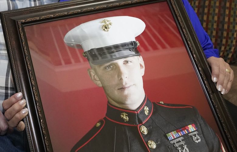FILE – Joey and Paula Reed pose for a photo with a portrait of their son Marine veteran and Russian prisoner Trevor Reed at their home in Fort Worth, Texas, Feb. 15, 2022. (AP Photo/LM Otero, File) WX211 WX211
