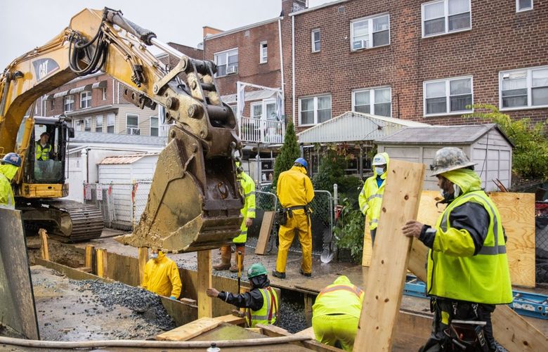Workers on a construction site repair damage from Hurricane Ida in the East Elmhurst neighborhood in the Queens borough of New York, U.S., on Tuesday, Oct. 26, 2021.  Photographer: Jeenah Moon/Bloomberg
