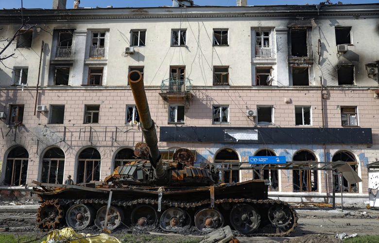 A destroyed tank and a damaged apartment building from heavy fighting are seen in an area controlled by Russian-backed separatist forces in Mariupol, Ukraine, Tuesday, April 26, 2022. (AP Photo/Alexei Alexandrov) MAR151 MAR151